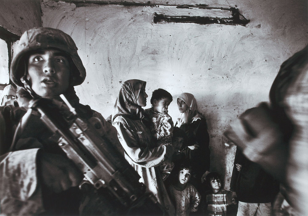 Anja Niedringhaus: Amerikanische Marineinfanteristen führen eine Razzia im Haus eines irakischen Abgeordneten im Stadtteil Abu Ghraib durch; Bagdad, Irak, November 2004. Pigmentdruck auf Barytpapier, 29,7 x 42 cm; Kunstpalast © picture alliance / AP Images